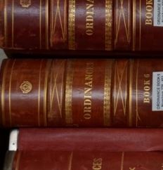 Red hardbound volumes of paper copies of ordinances